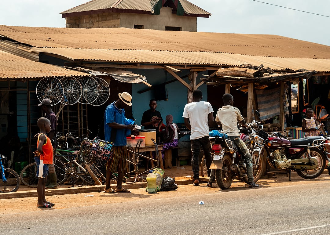 People standing in front of shops by roadside