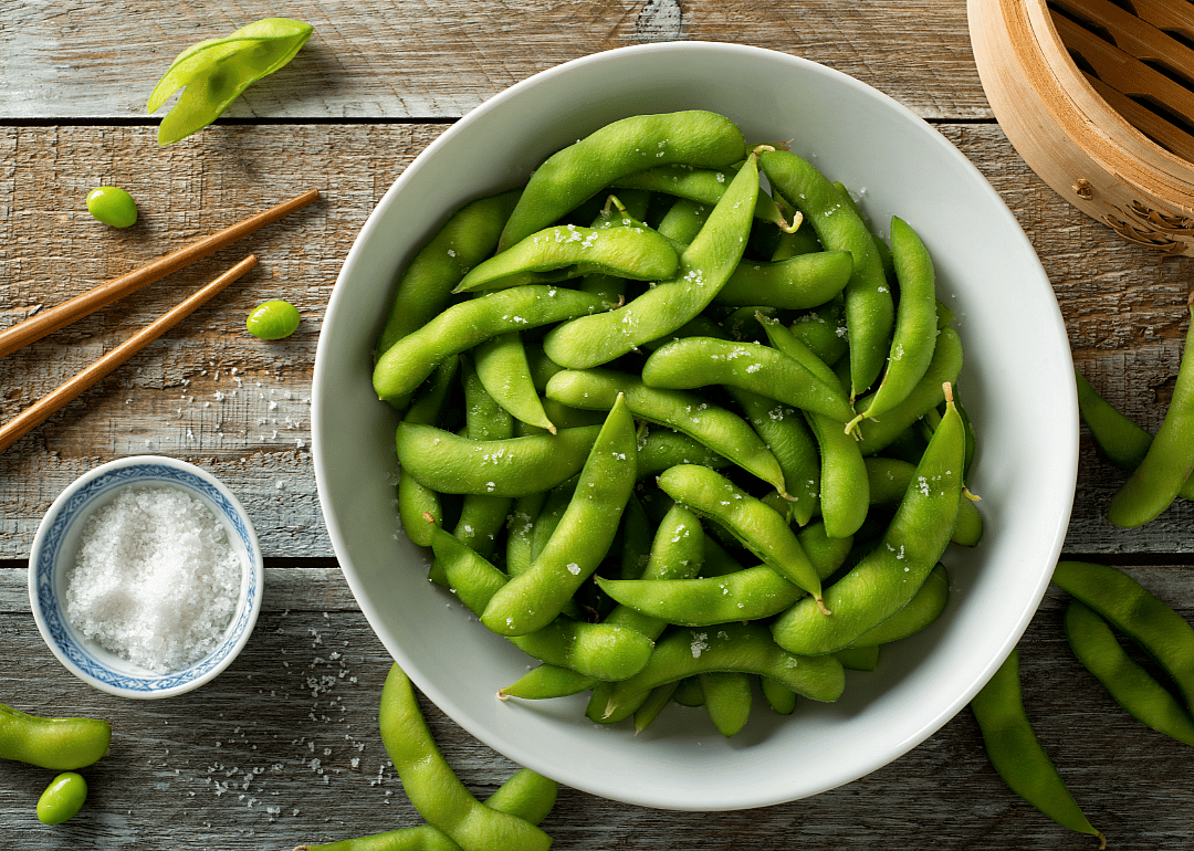Bowl of edamame with chopsticks.
