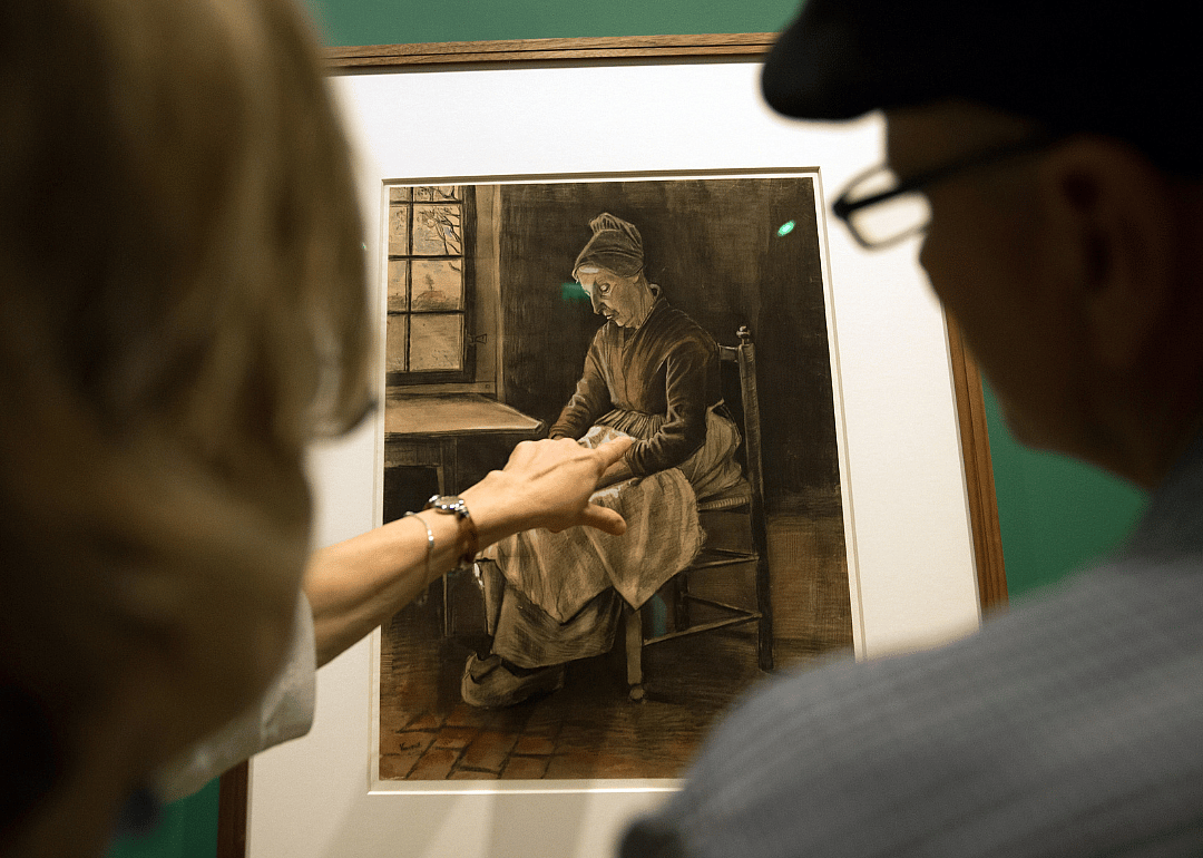 People look at a drawing entitled 'Woman Sewing, Etten, 1881' by Vincent van Gogh.