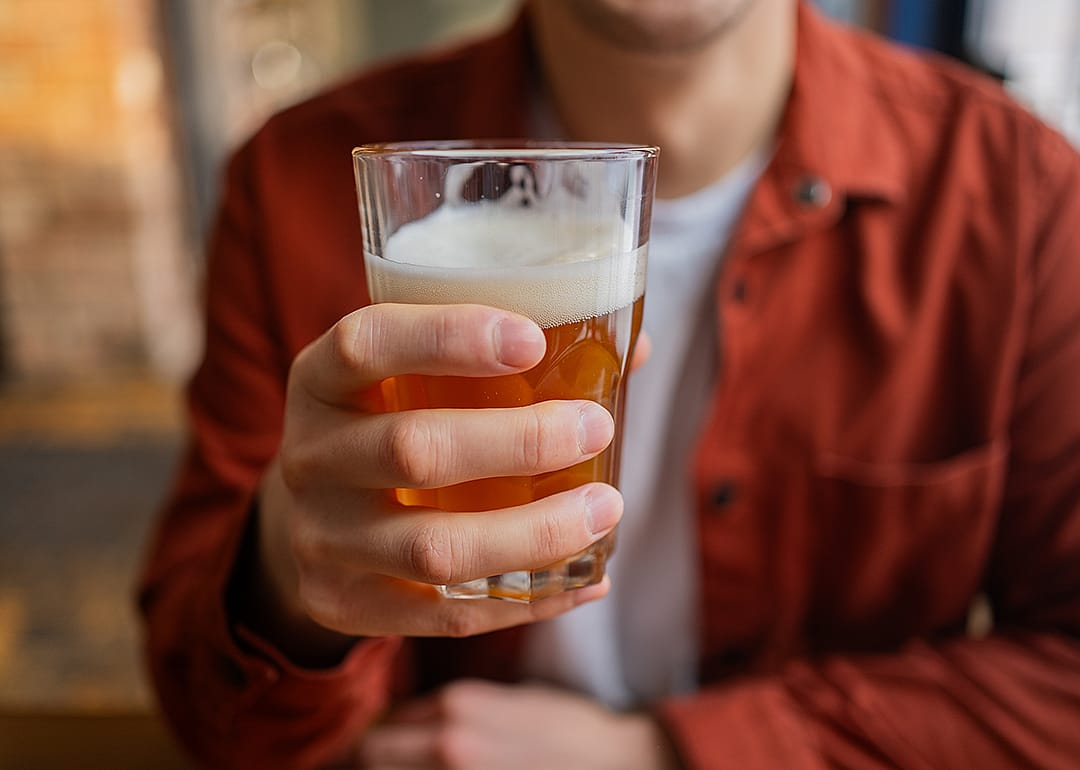 Close up view of hand holding craft beer.