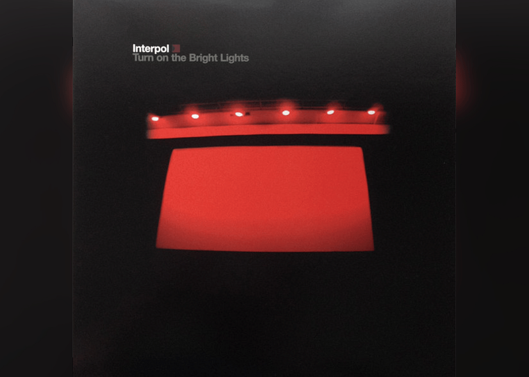 The side of a red building with lights on the top.
