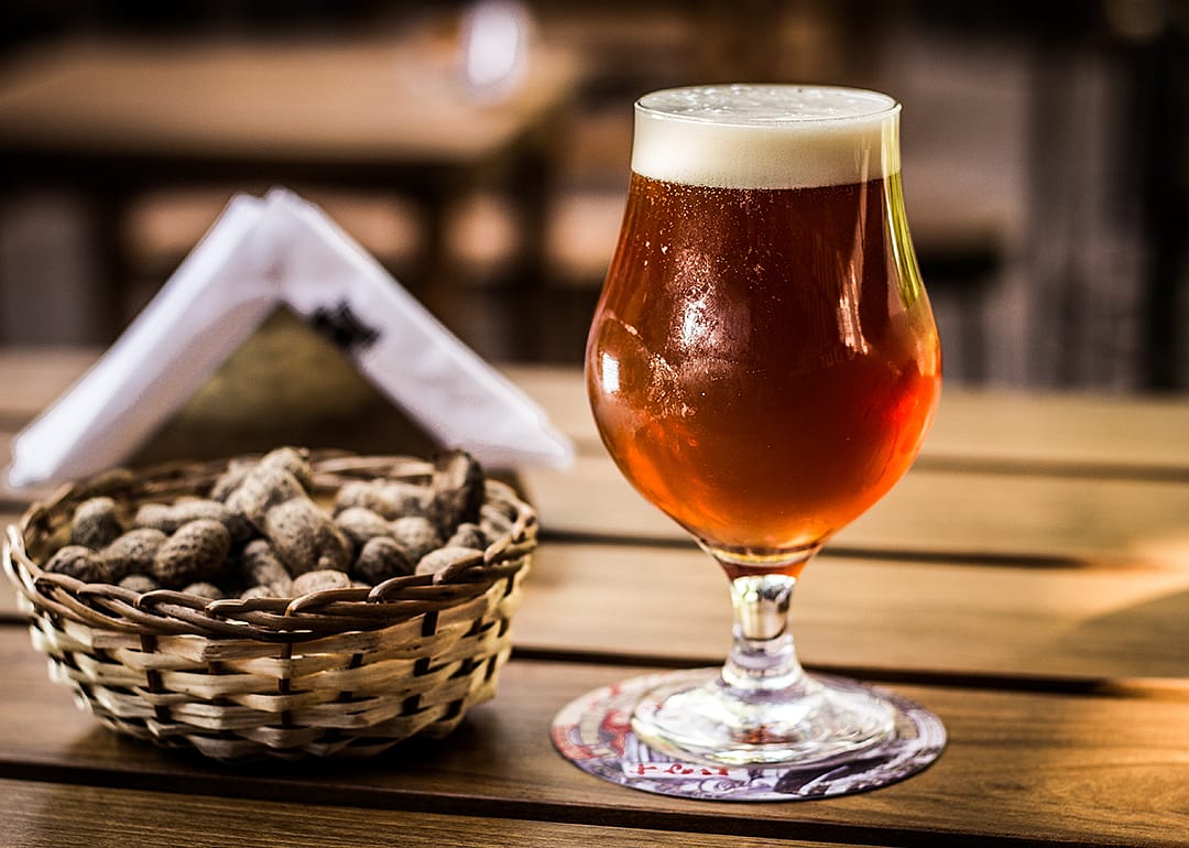 Barley wine beer glass with peanuts.