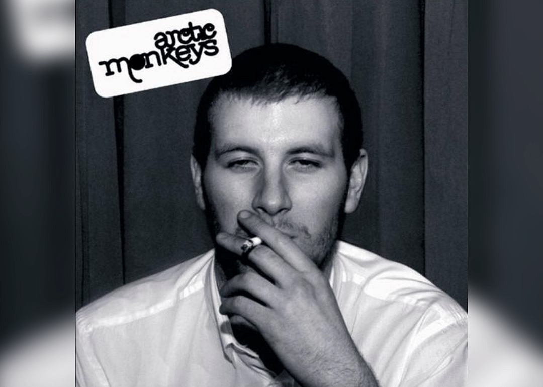A man in a white shirt smoking a cigarette.