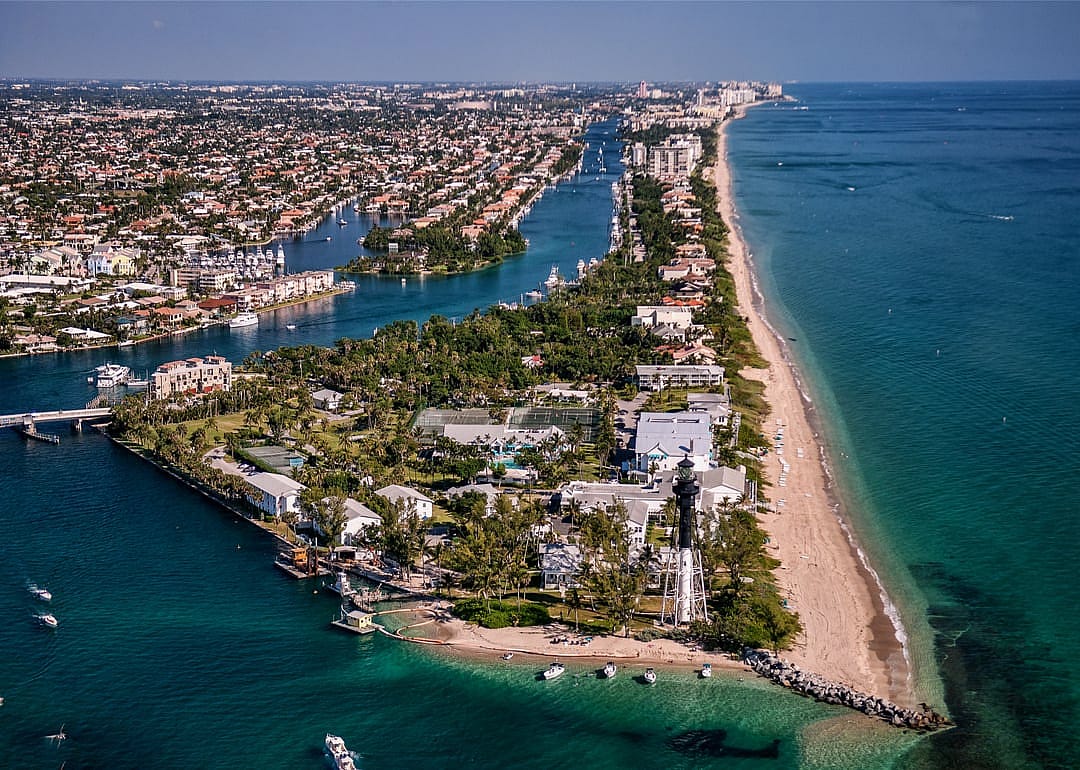 Aerial view of lighthouse and boating inlet.