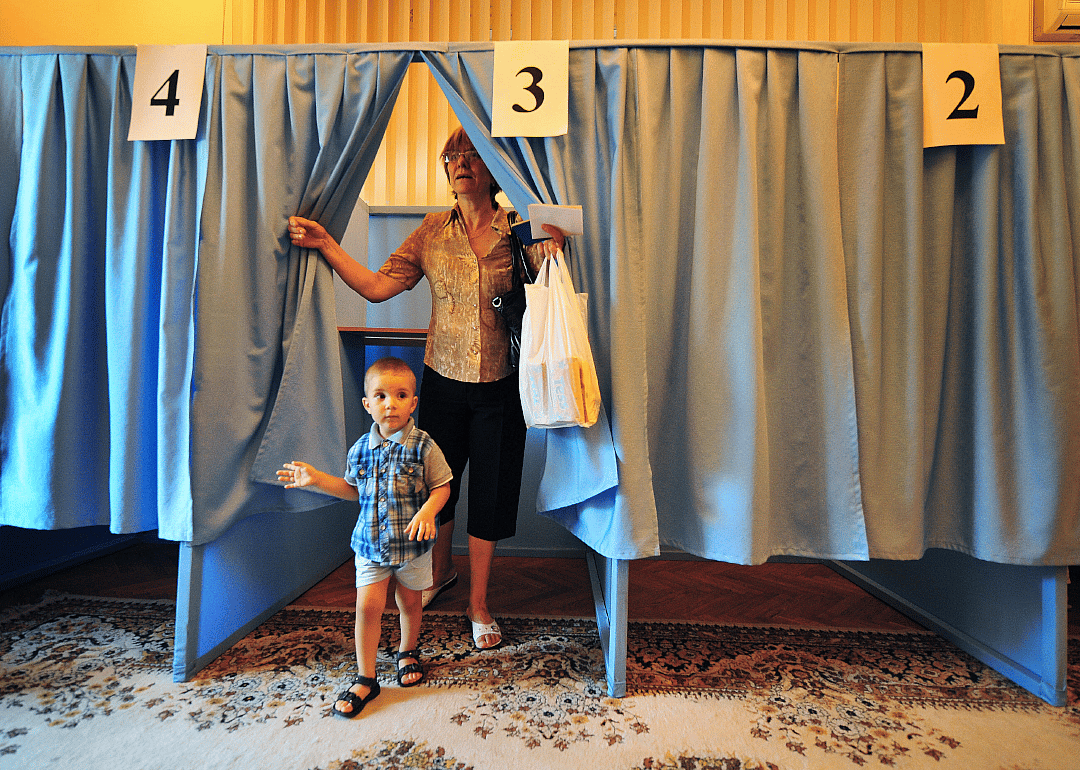 A Moldovan woman and a child exit voting boot