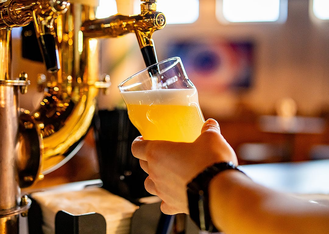 Bartender filling pint.