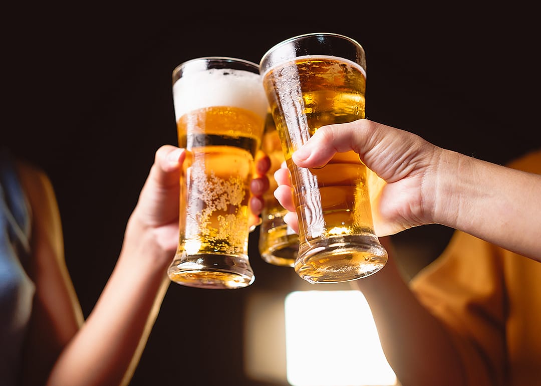 Hands raising beer glasses to cheers.