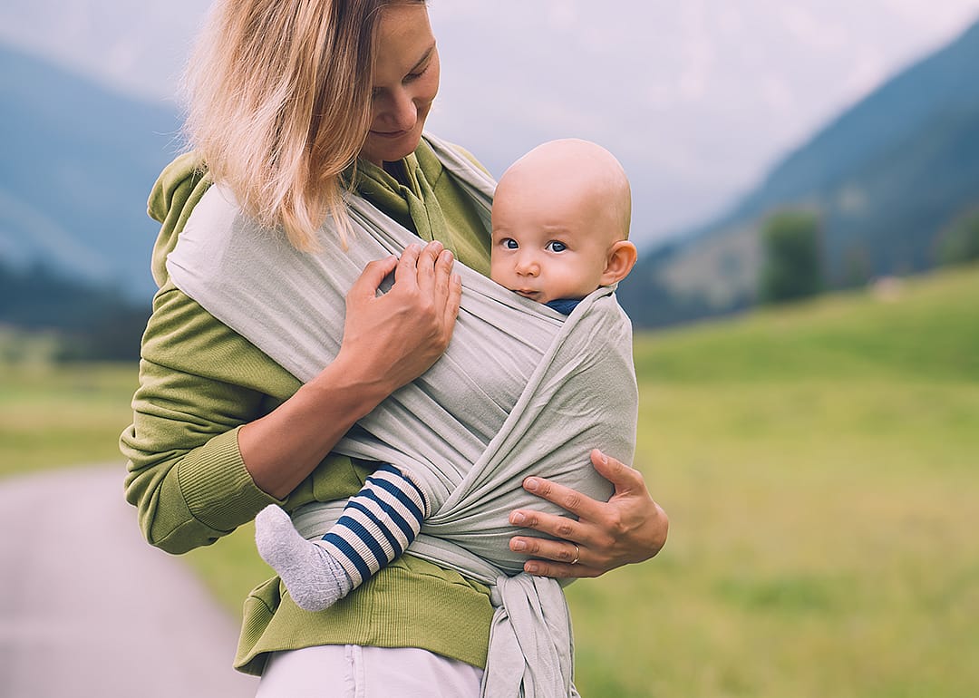 Mother carrying baby on trail.
