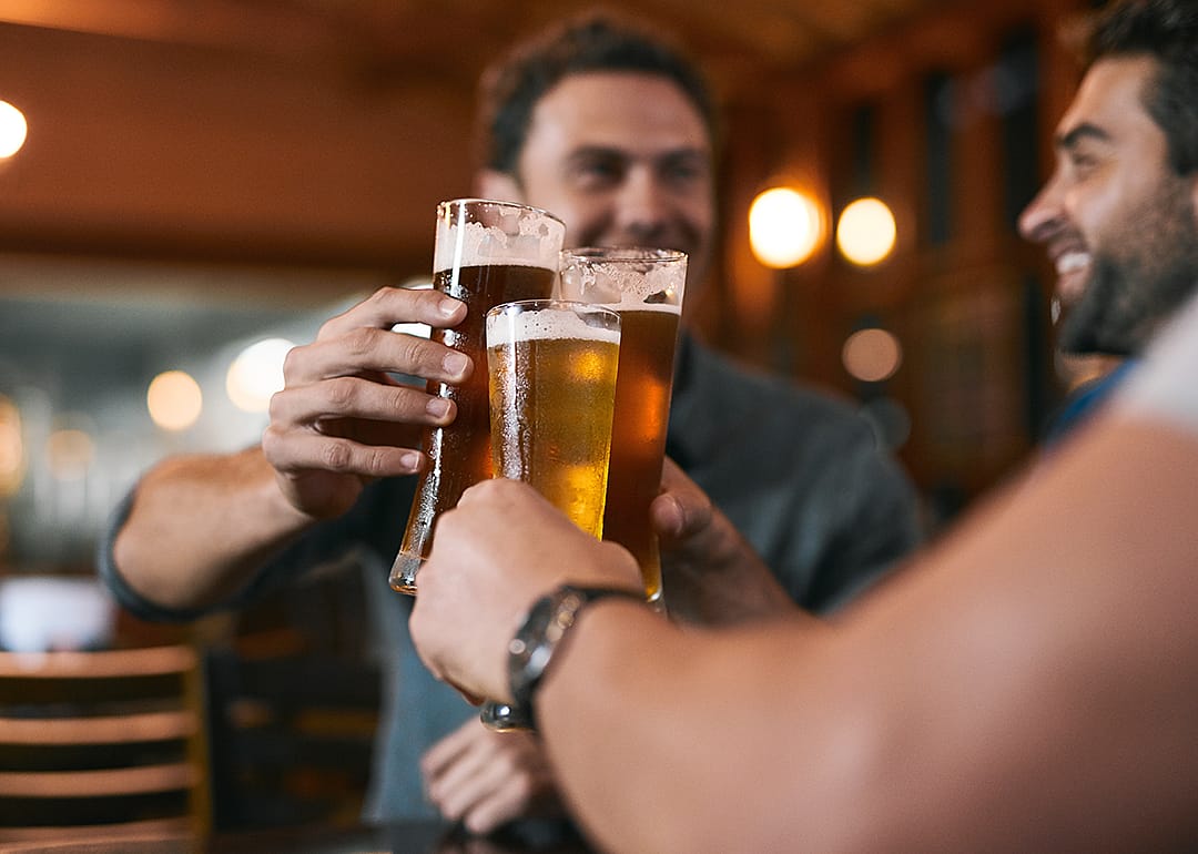 Friends raising beer glasses to cheers.
