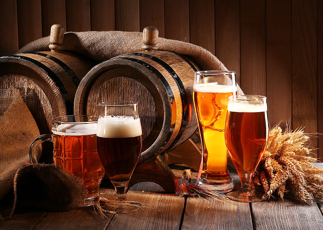 Barrel with beer glasses on table.