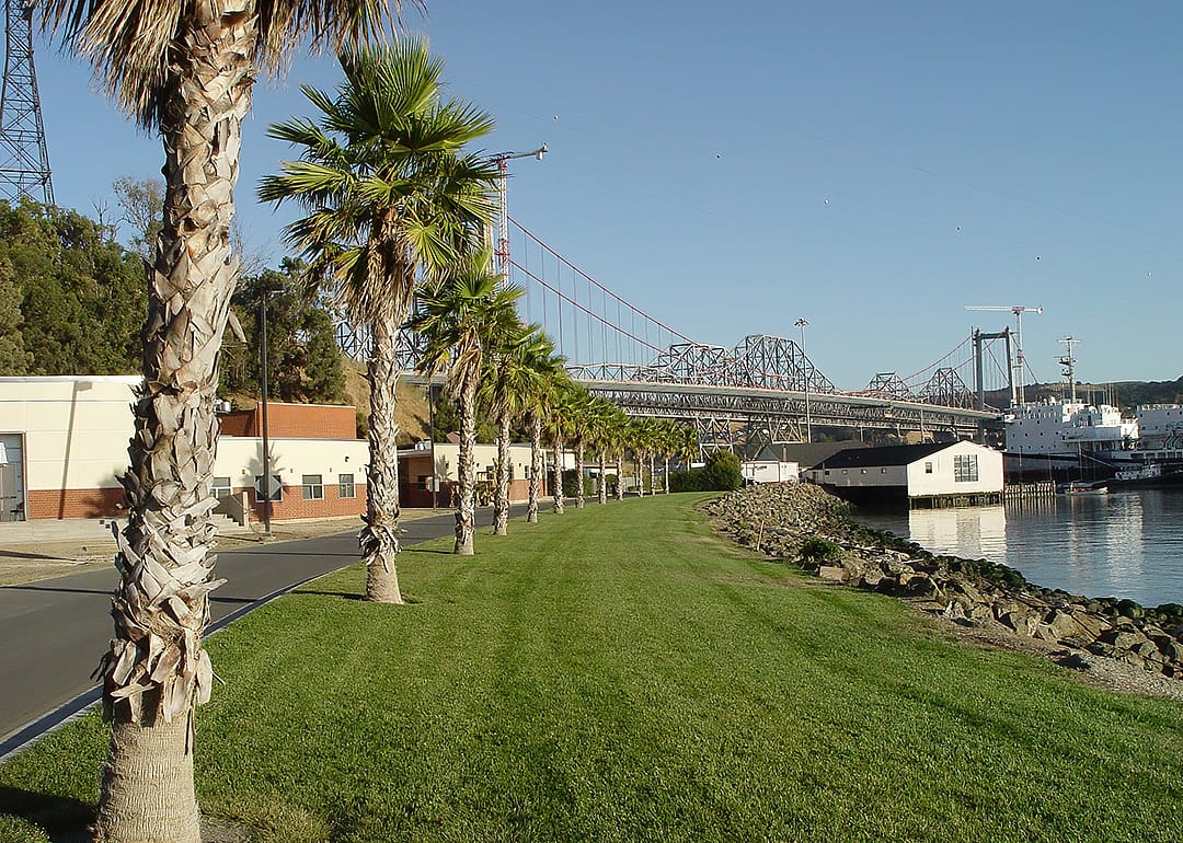 California Maritime Academy Campus with palm trees, bridge and training boat.
