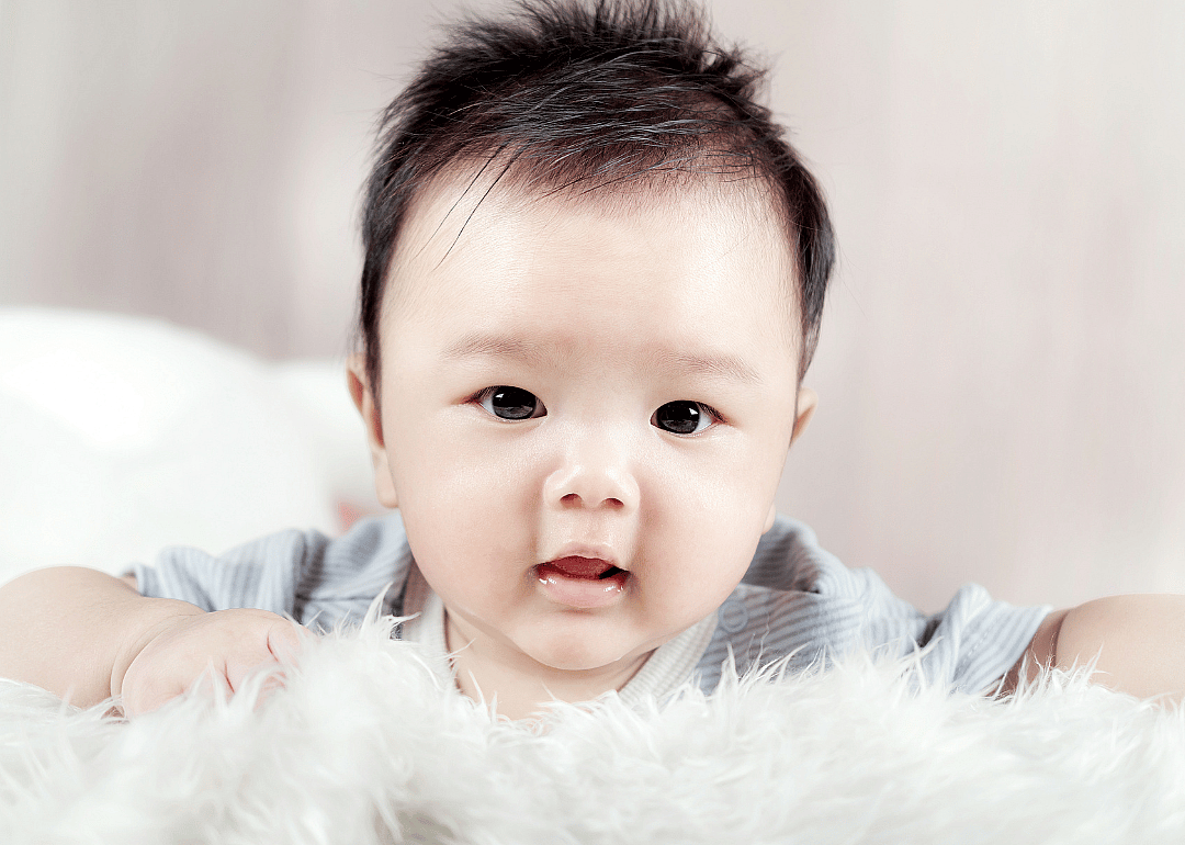 Asian baby boy lying on the fluffy blanket.