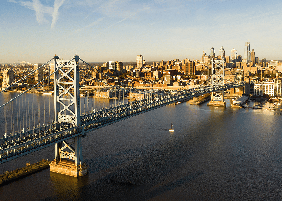 A tall suspended bridge over the river with city views.