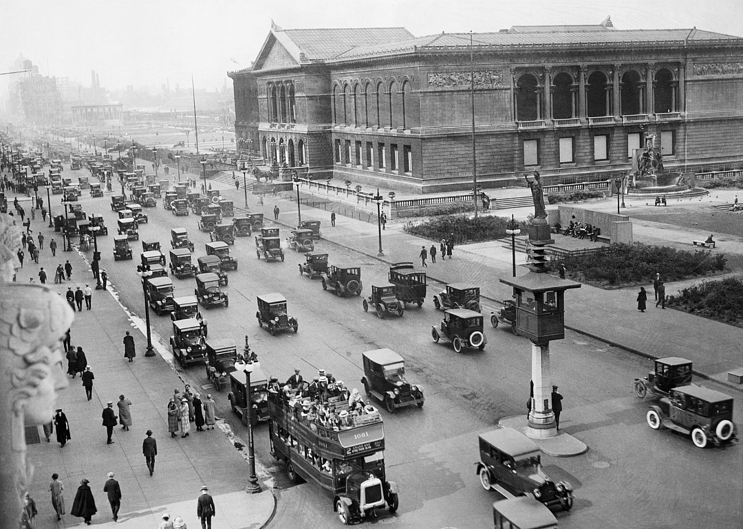 Passersby and cars congregate in the front of the Chicago Art Institue