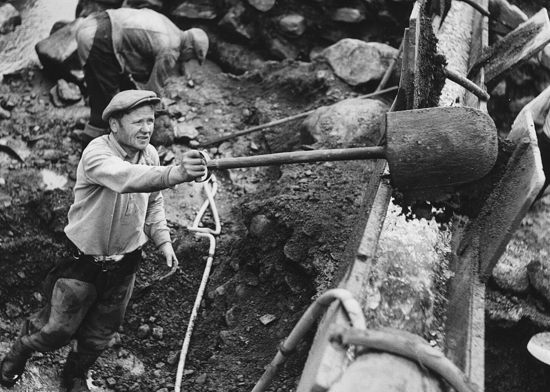 A worker shovels dirt.
