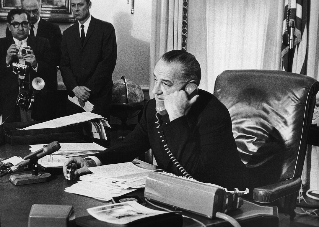 President Lyndon B. Johnson talks on a phone in the Oval OFfice.