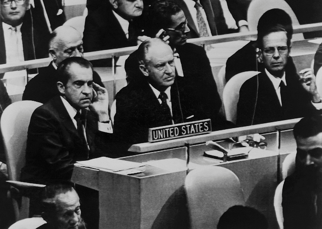 President Nixon, left, listens to remarks at an N