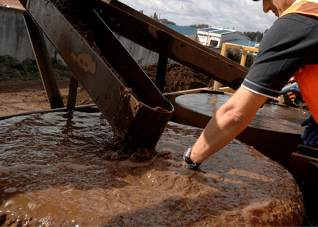 A worker sifts through water in search of gold.