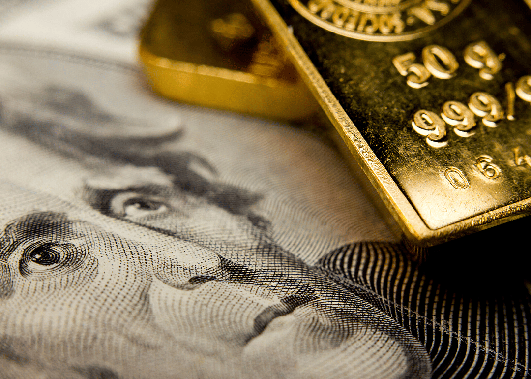 A paper bill and gold bullion bar.