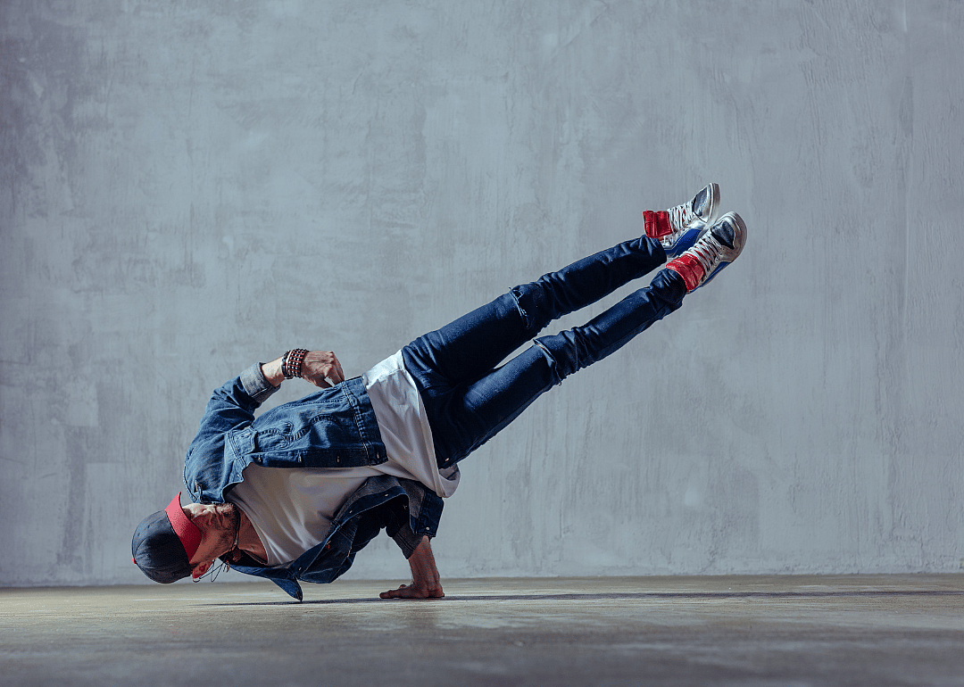 A dancer leaning on his one hand with the rest of his body suspended in the air.