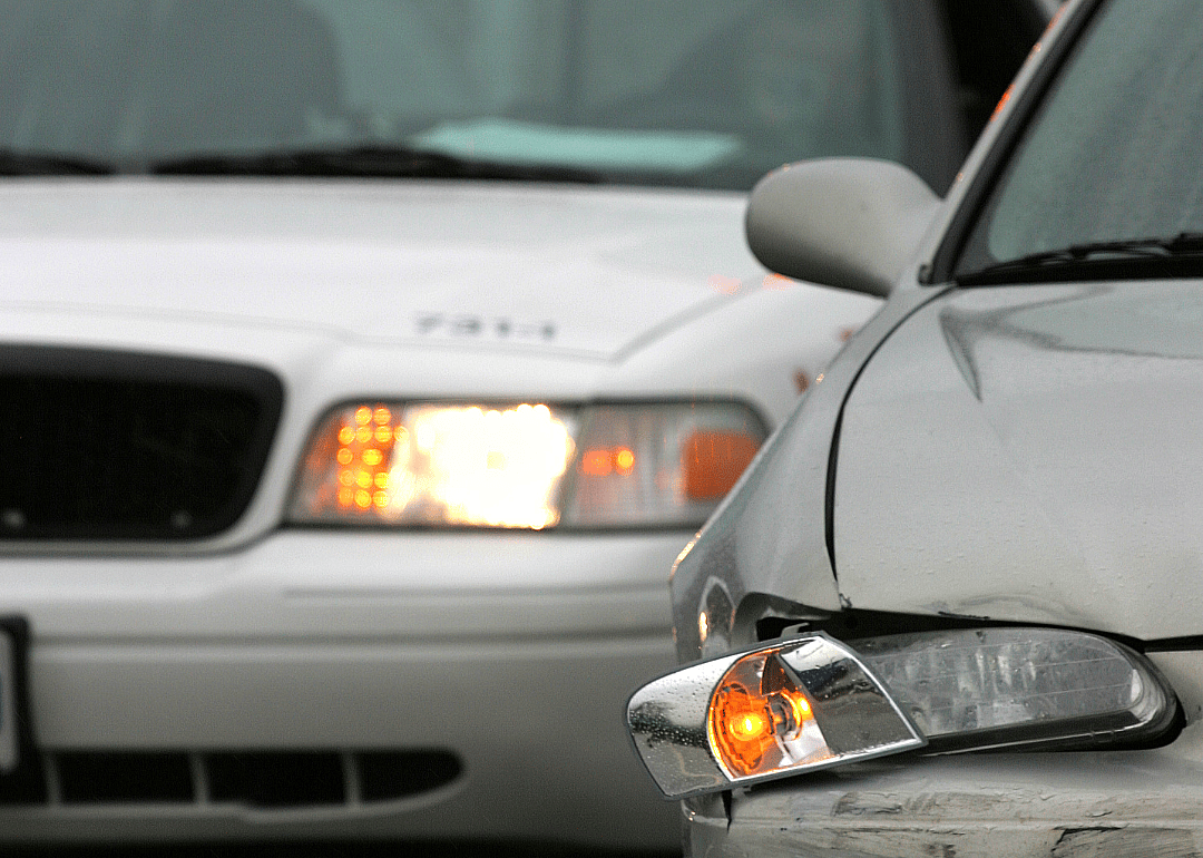A police car pulling up to a minor car crash.