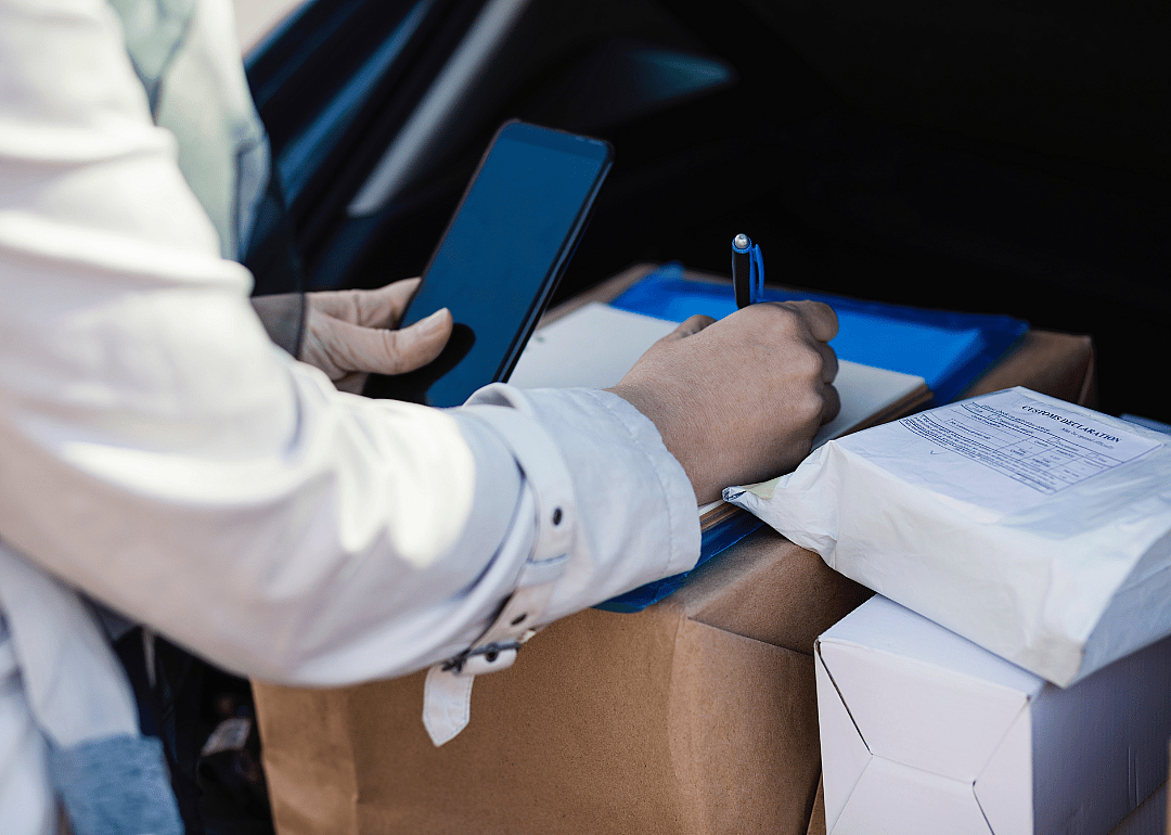 A person making deliveries from the back of a car.