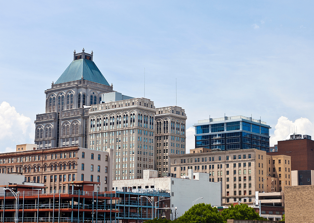 A city skyline with tall buildings and parking lots.