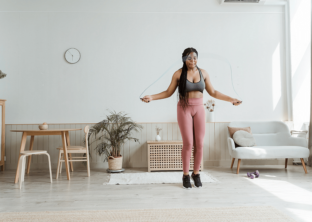 A woman jumping rope in her living room.