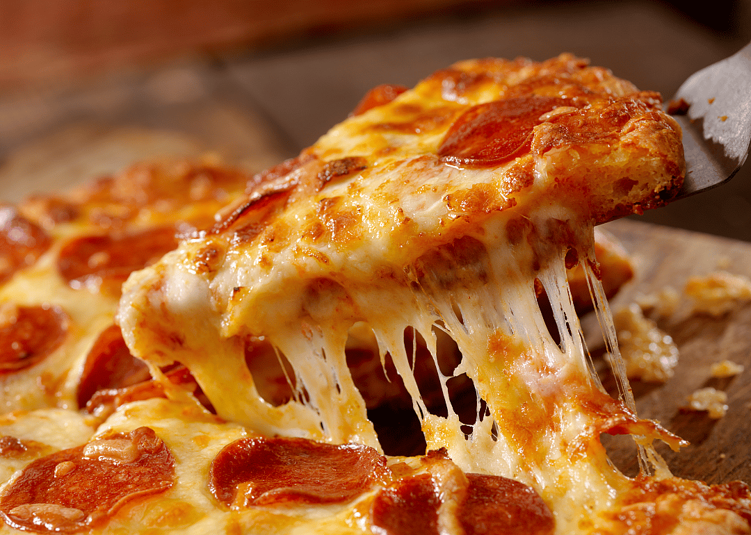 Slice of pizza being pulled from a pan.