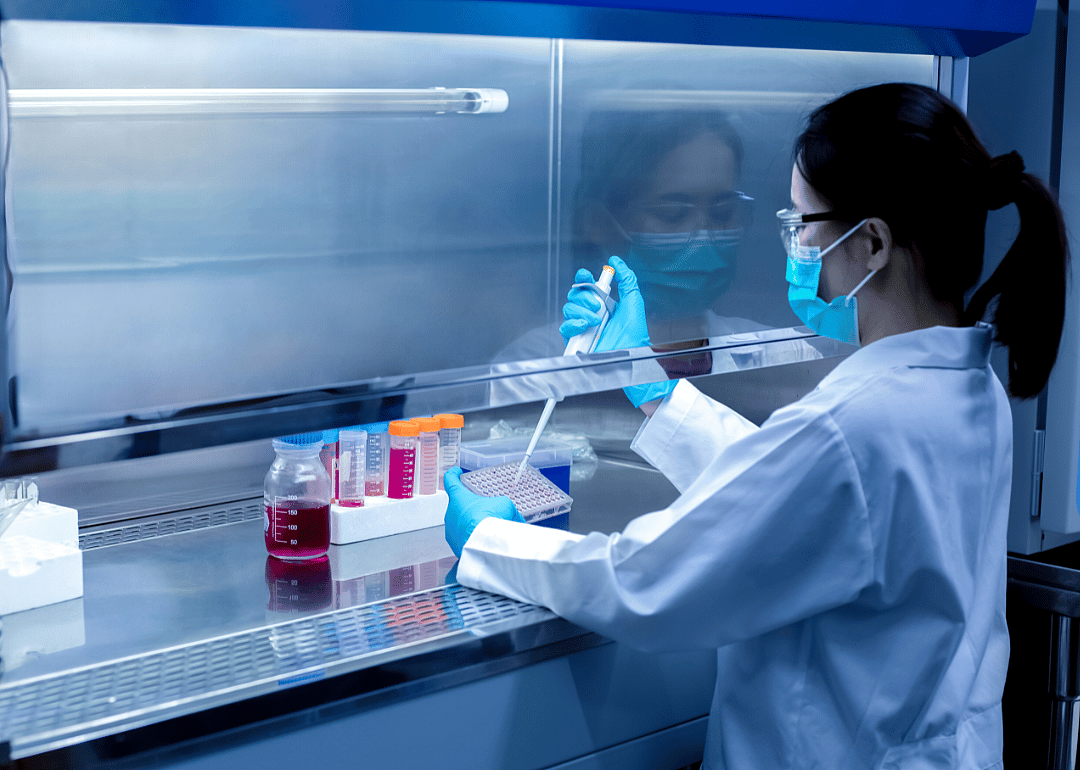 A scientist working with liquid in test tubes.