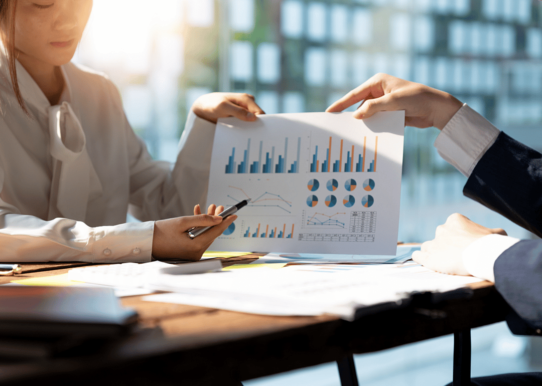 Two women review investment data in an office setting