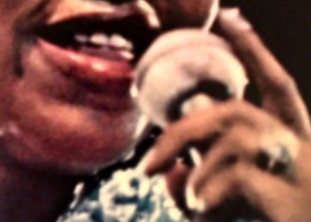 A hand, a microphone, and a mouth.