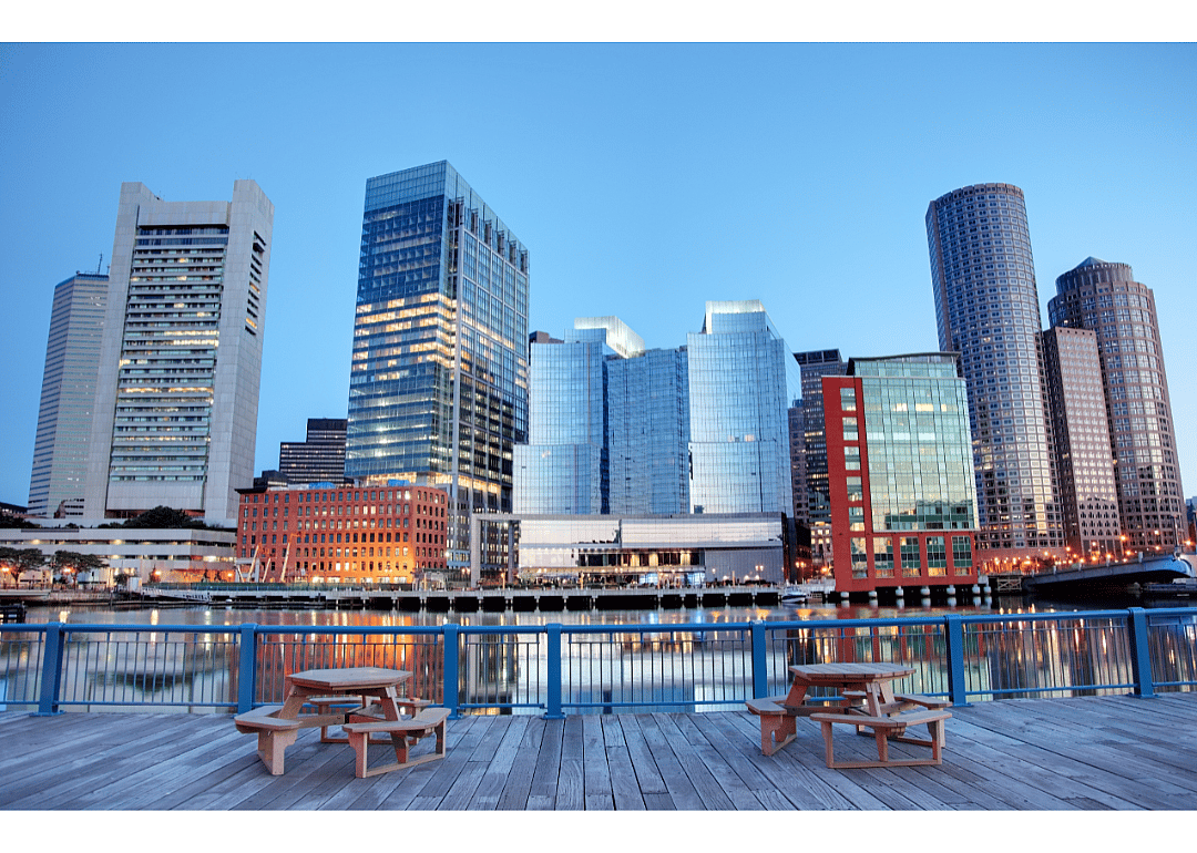 City skyline with glass, steel, and concrete buildings by the river.