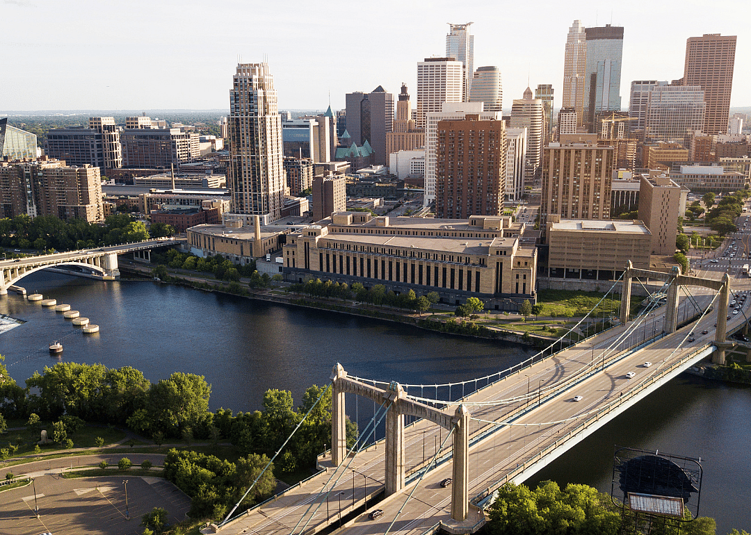 City skyline by the river with a bridge in the foreground.