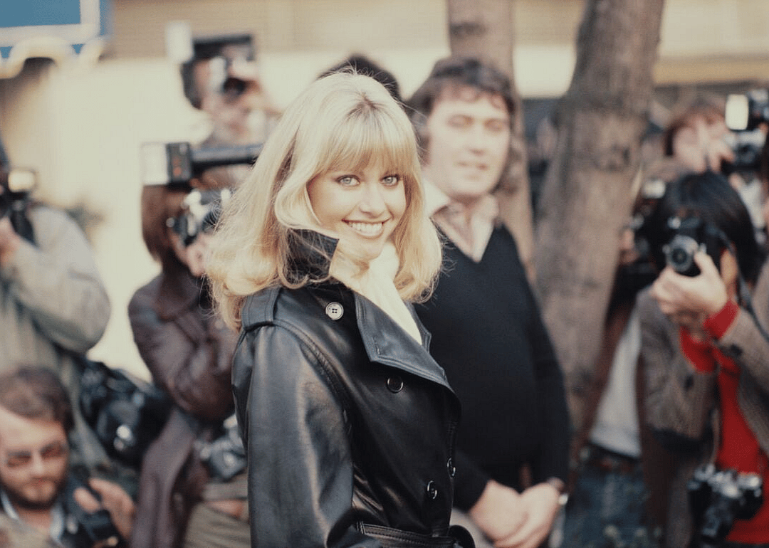 Olivia Newton-John smiling for photographers.