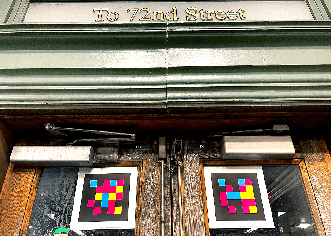 NaviLens, a colorful QR code, displayed on the doors of the entrance to the 72nd Street subway station in New York City.