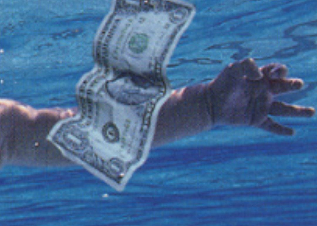 A dollar bill and a hand underwater.
