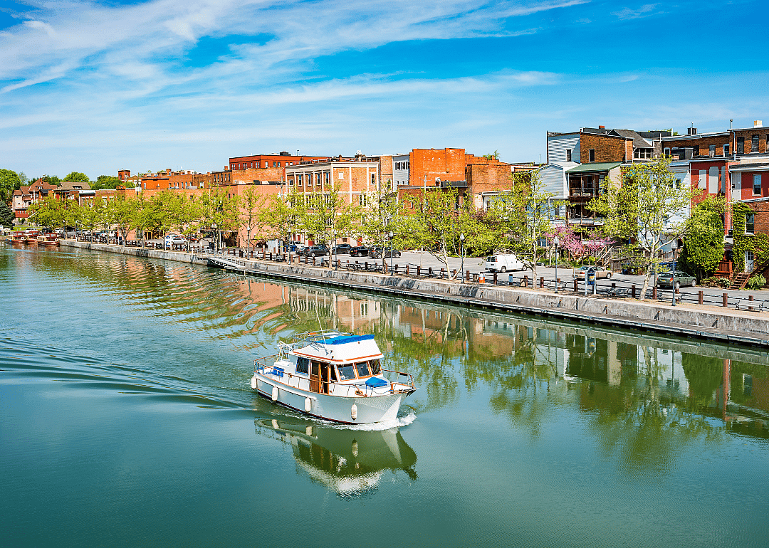 Row of brick buildings by the canal with a boat.