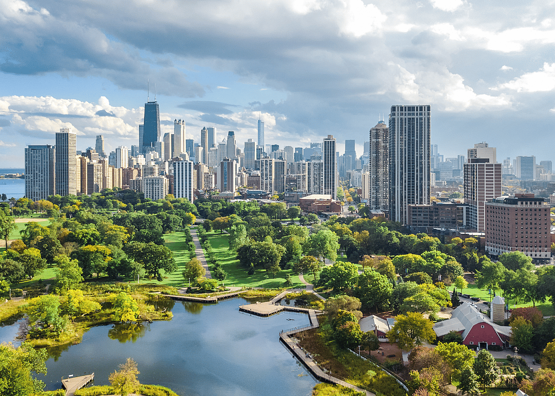 An aerial view of green parks and trees with the Chicago skyline in the background.