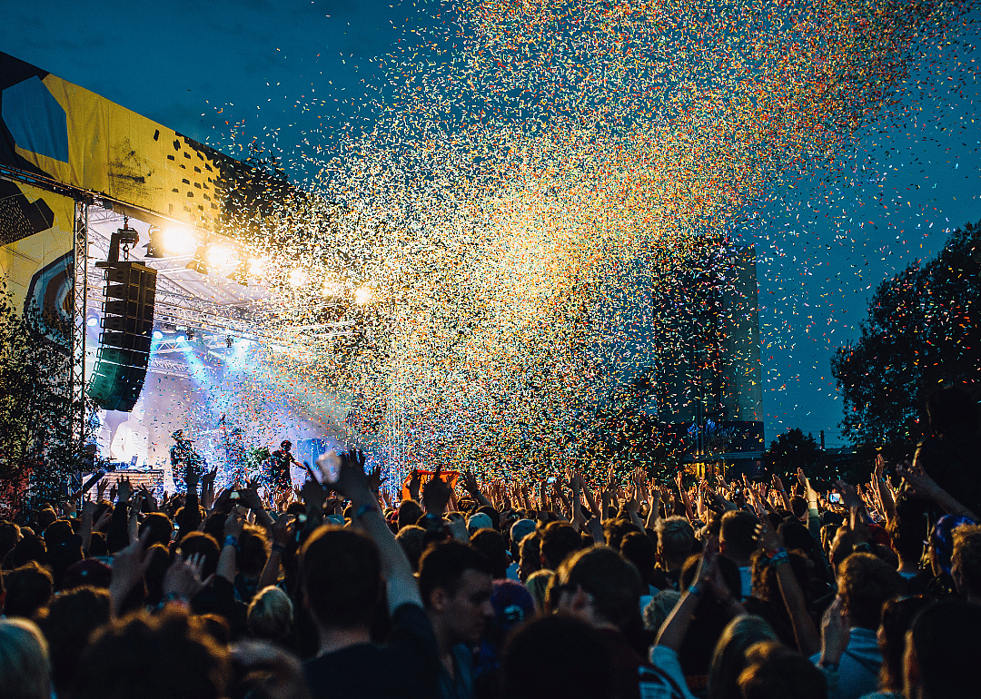 Confetti drops on an crowd watching an outdoor concert.