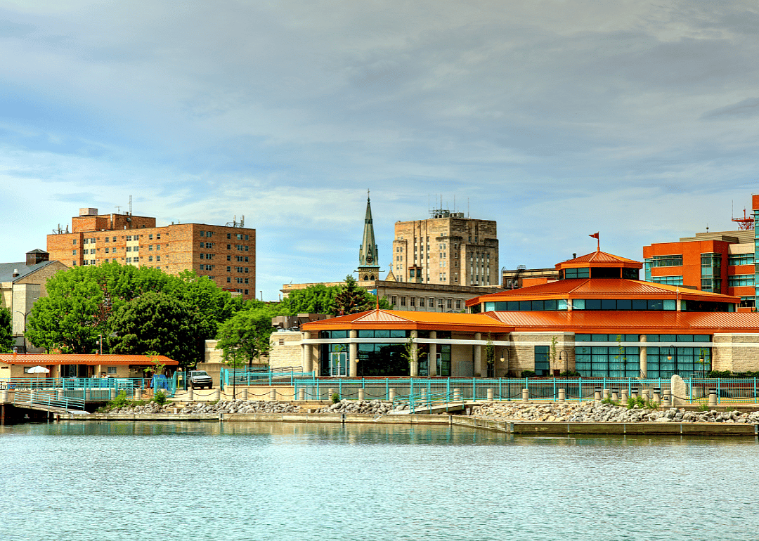 A city's skyline, with a river in the foreground.