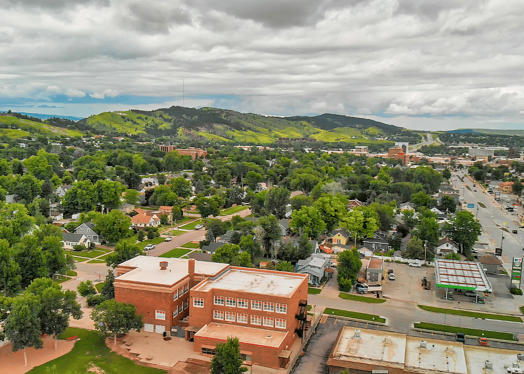 A city downtown surrounded by green hills.