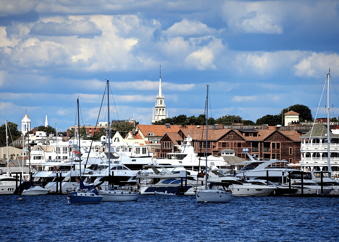 Wooden buildings by the water with boats in the foreground.