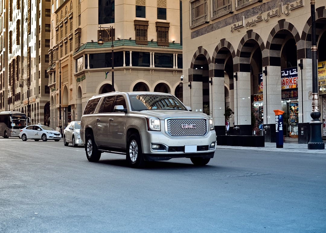 A GMC Yukon driving down a city street.