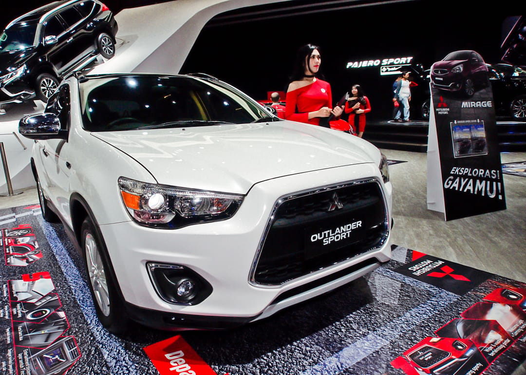 A white Mitsubishi Outlander Sport in a showroom.