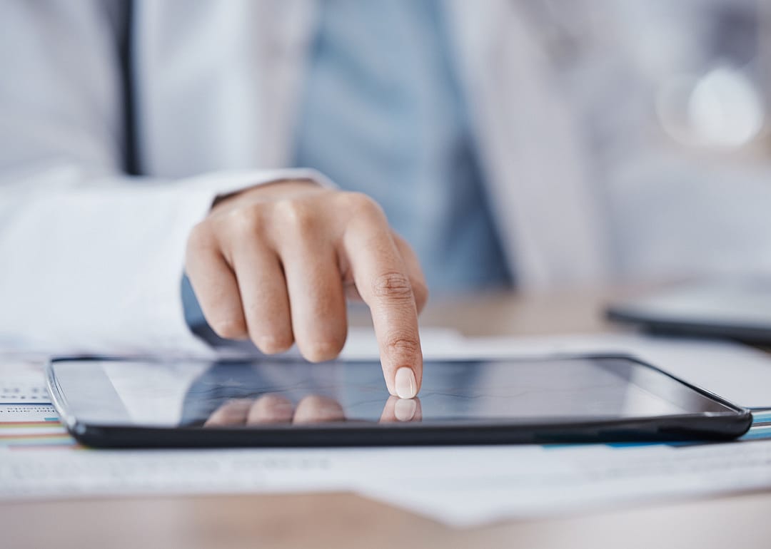 Female doctor's hand on a tablet.