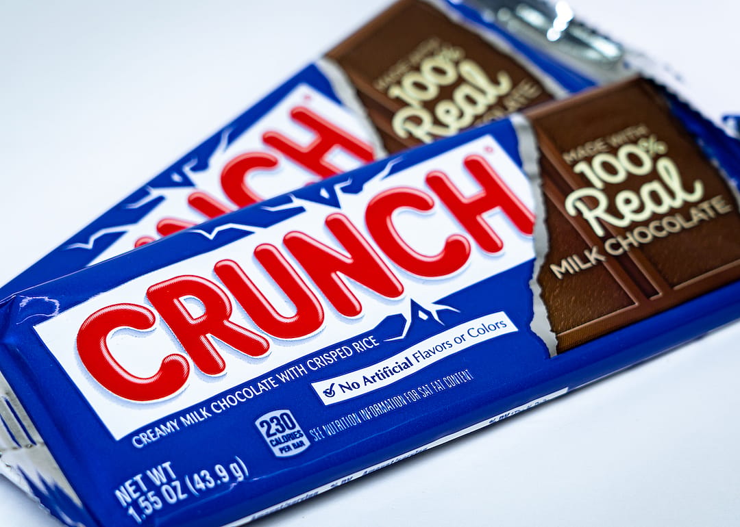 Two bars of Nestle Crunch chocolate bar on a white background.