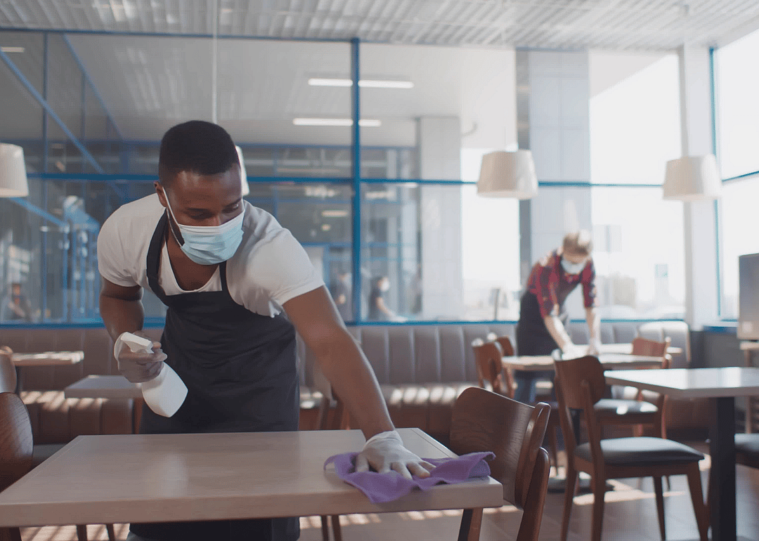 Cafeteria attendants cleaning tables