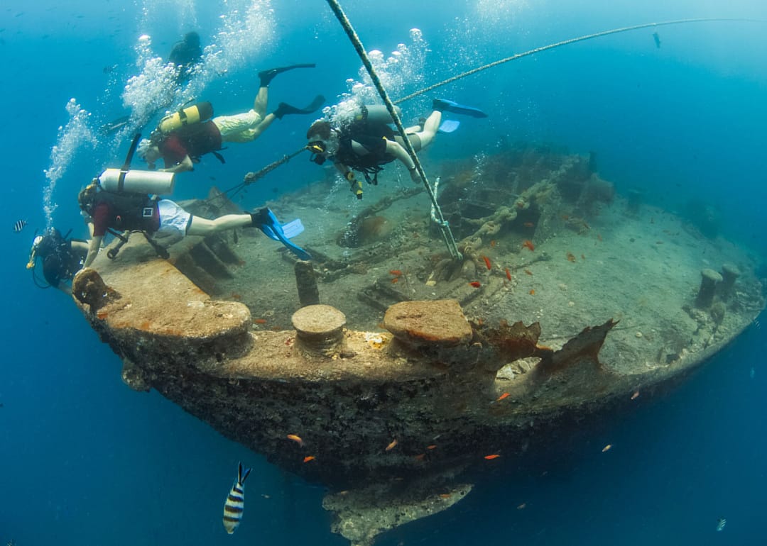 Scuba divers in the bow of the Thistlegorm shipwreck in the Red Sea.