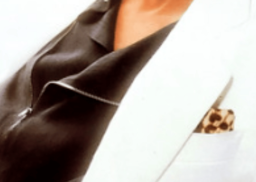 A zipped black shirt, a white jacket and a leopard pocket square.